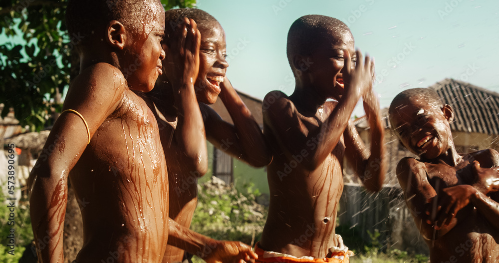 Group of African Kids Jumping and Laughing when Water Gets Poured on Them. Happy and Innocent Black 