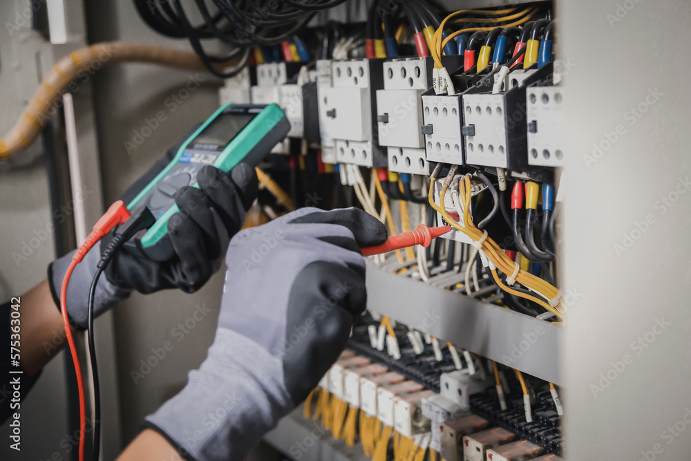 Electricity and electrical maintenance service, Engineer hand holding AC multimeter checking electri