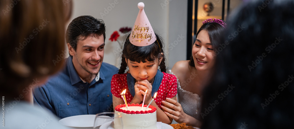 Multi-ethnic big family having a birthday party for young kid daughter. 
