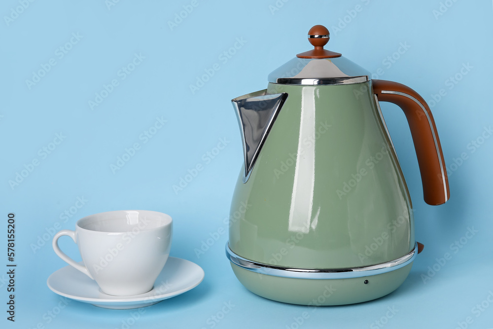 Electric kettle and cup on blue background