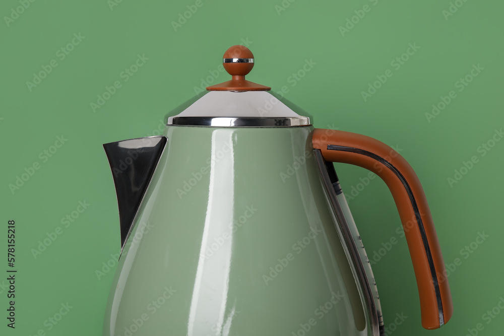 Electric kettle on green background, closeup