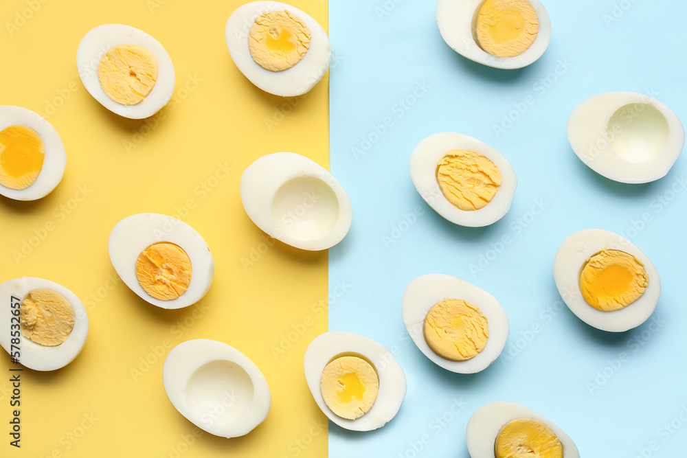 Many halves of delicious boiled eggs on blue and yellow background