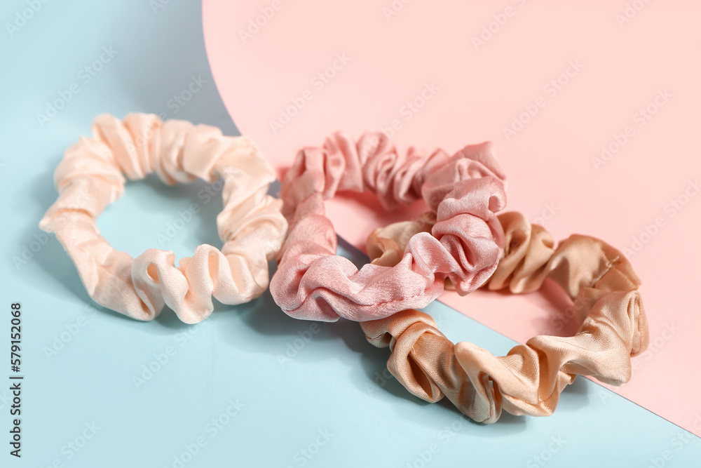 Set of silk scrunchies on color background, closeup
