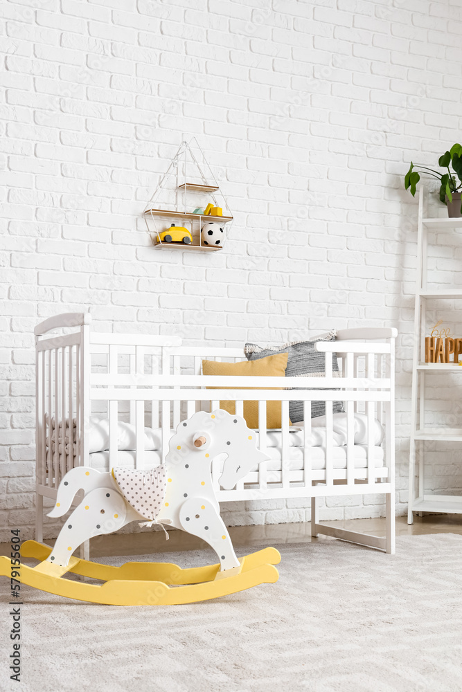 Interior of childrens bedroom with crib and rocking horse
