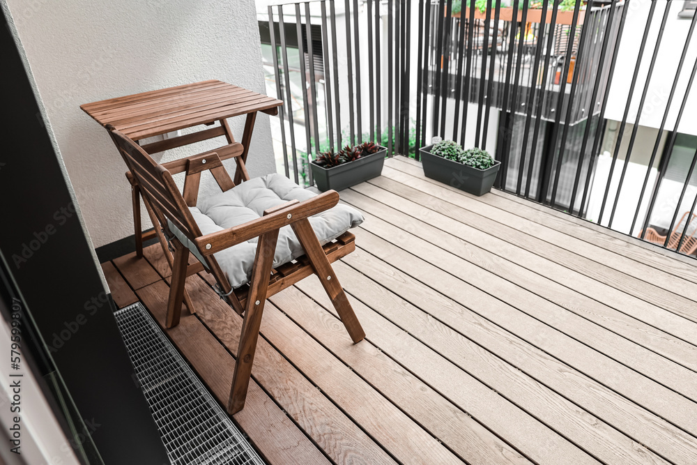 Wooden chair and table on modern balcony