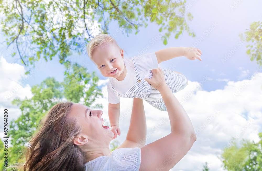 Healthy child (kid) having fun with mother in the sunny summer day at the park. Caucasians happy bab