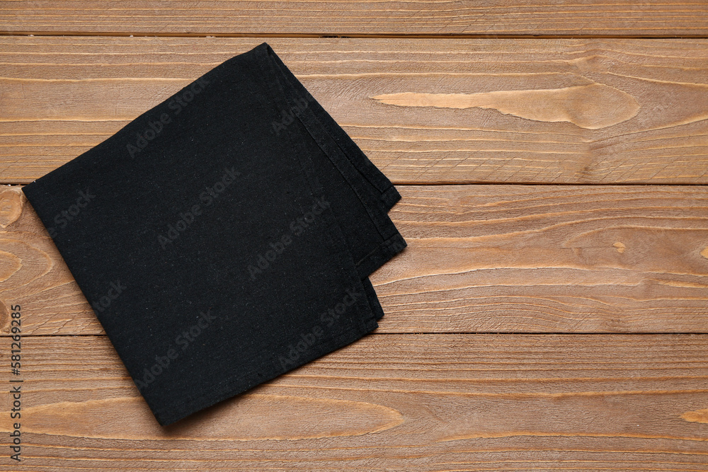 Black folded napkin on wooden background