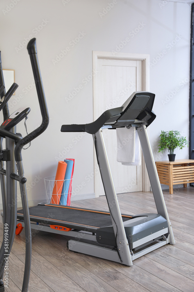 Interior of gym with modern treadmill and sport equipment