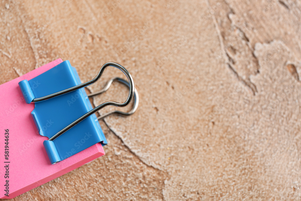 Sticky notes with binder clip on color background
