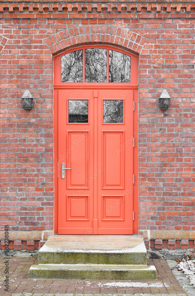 View of brick building with red wooden door
