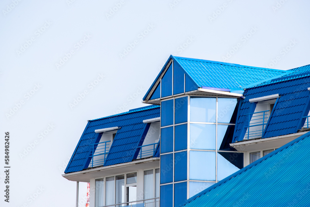 Roofs of houses with dormer windows against the sky. Urban architecture.