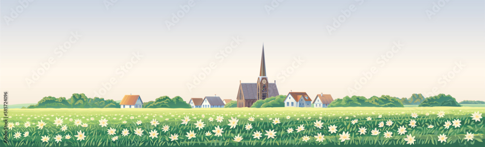 Rural landscape with a village in the background and a flowering meadow with a carpet of large flowe