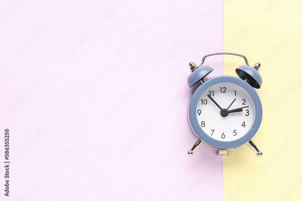 Vintage alarm clock on color background