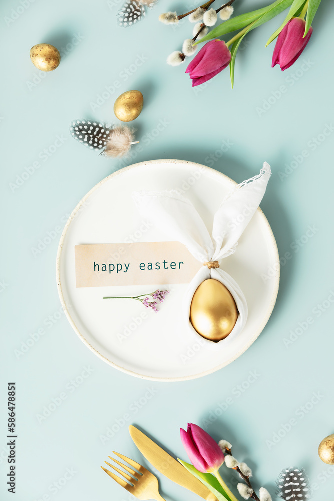 Stylish Easter flat lay with golden egg in easter bunny napkin on white plate, golden quail eggs, fe