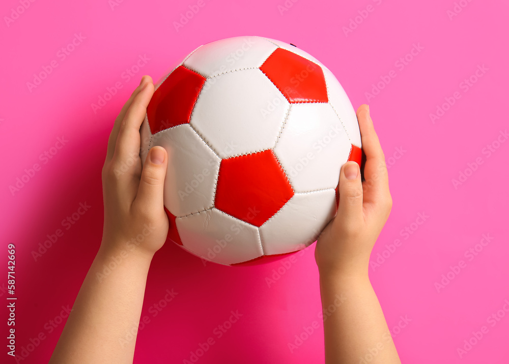 Hands with soccer ball on pink background