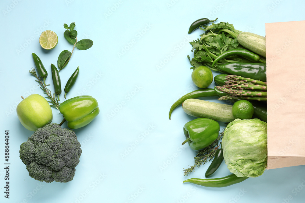 Composition with different fresh vegetables and fruits on blue background