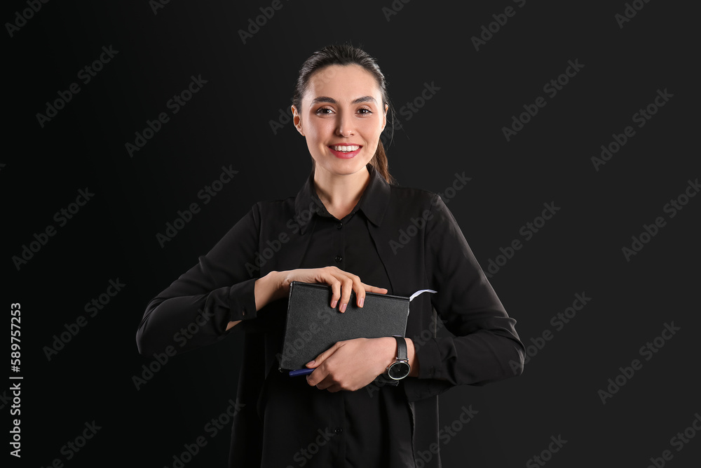 Female business consultant with notebooks on dark background
