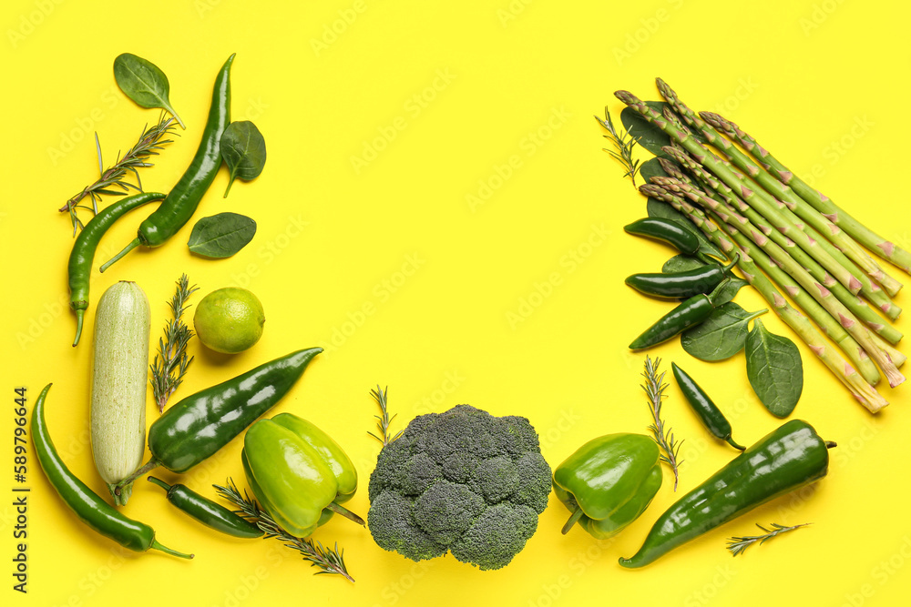 Frame made of different fresh vegetables on yellow background