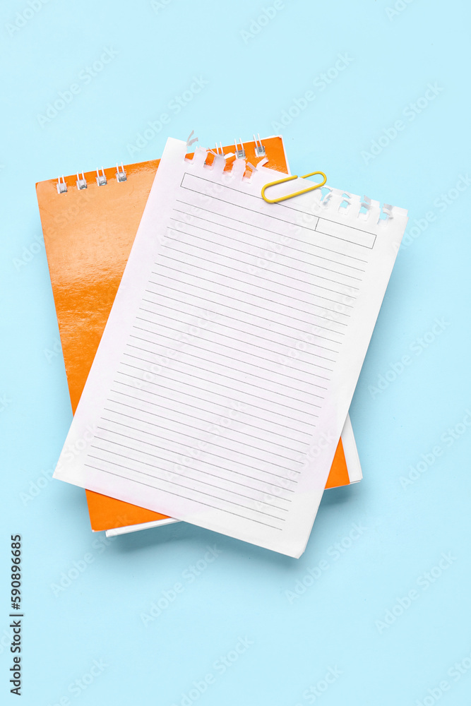 Paper sheet with clip and pen on blue background