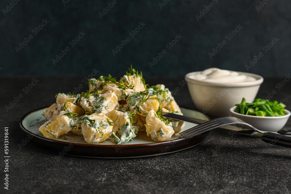 Plate of tasty Potato Salad with greens on dark background