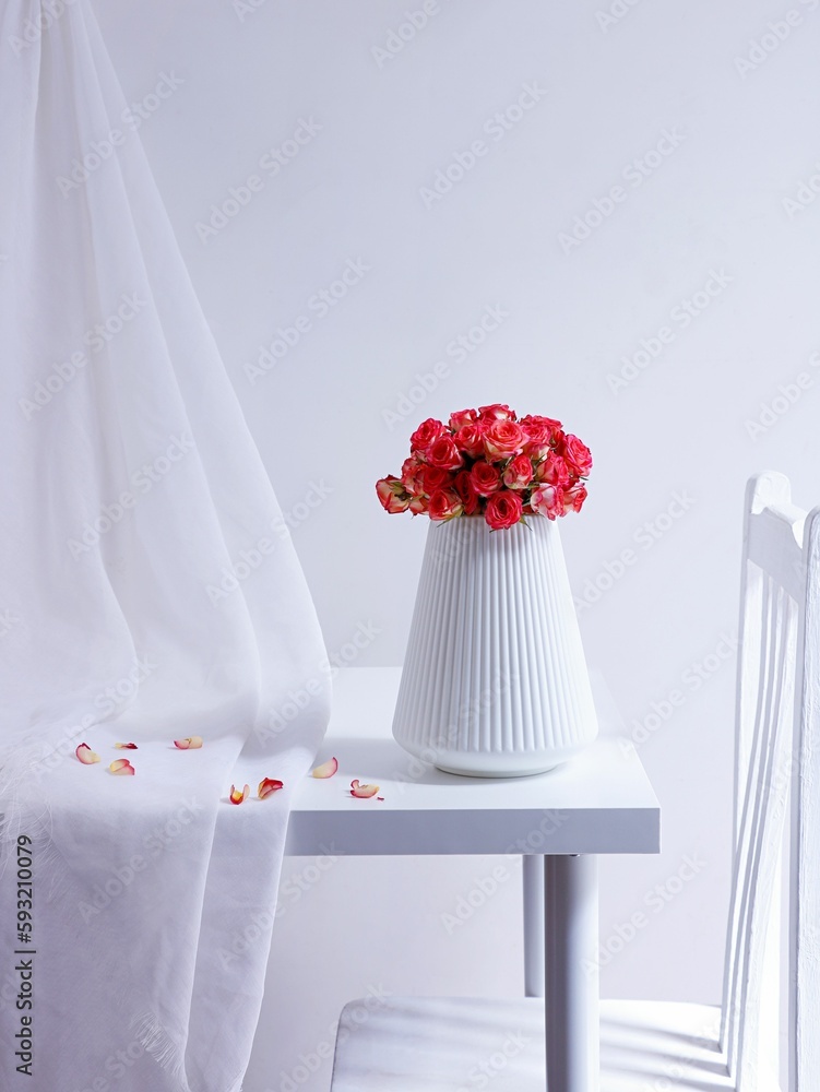 Beautiful view of a pink rose bouquet in a white vase on a minimalistic white table