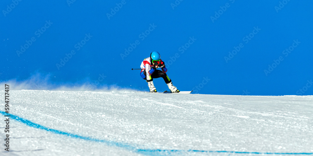 male ski racer on alpine skiing track downhill, snowy slope on blue sky background, winter sports ga
