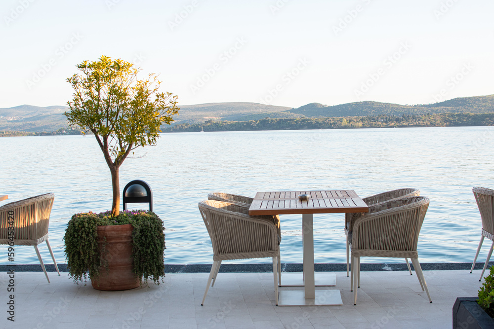 Restaurant table and chairs by the seaside. Summer tropical vacation concept. Relaxation idea.