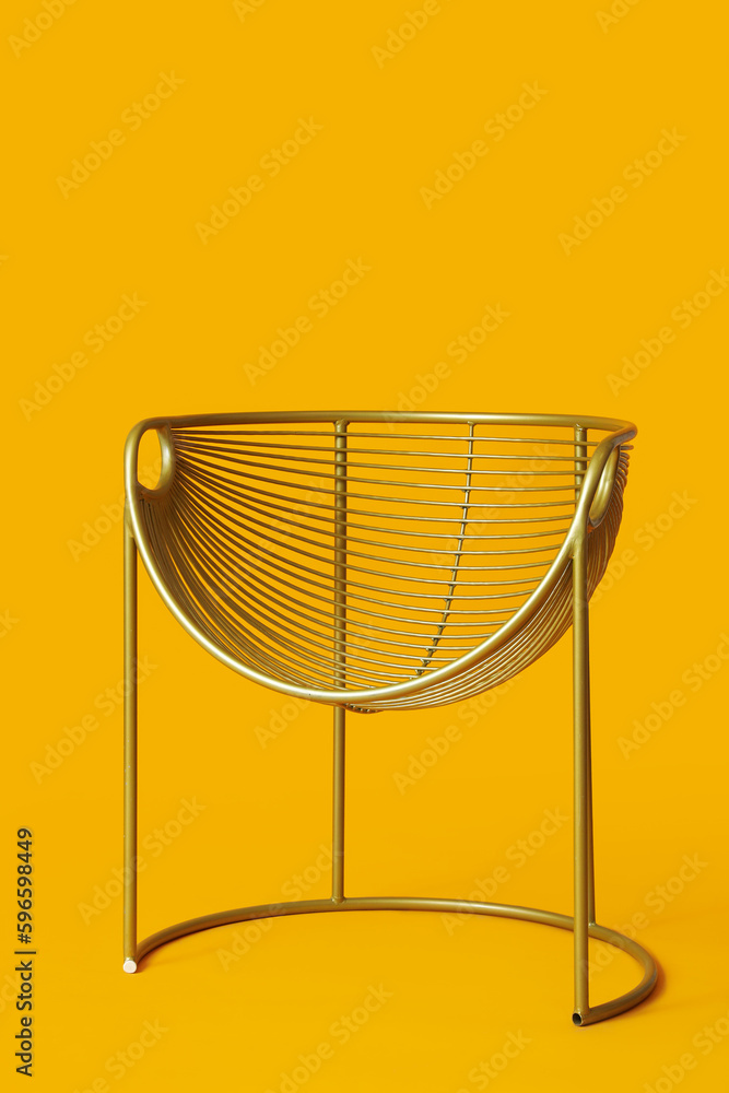 Modern metallic armchair on orange background