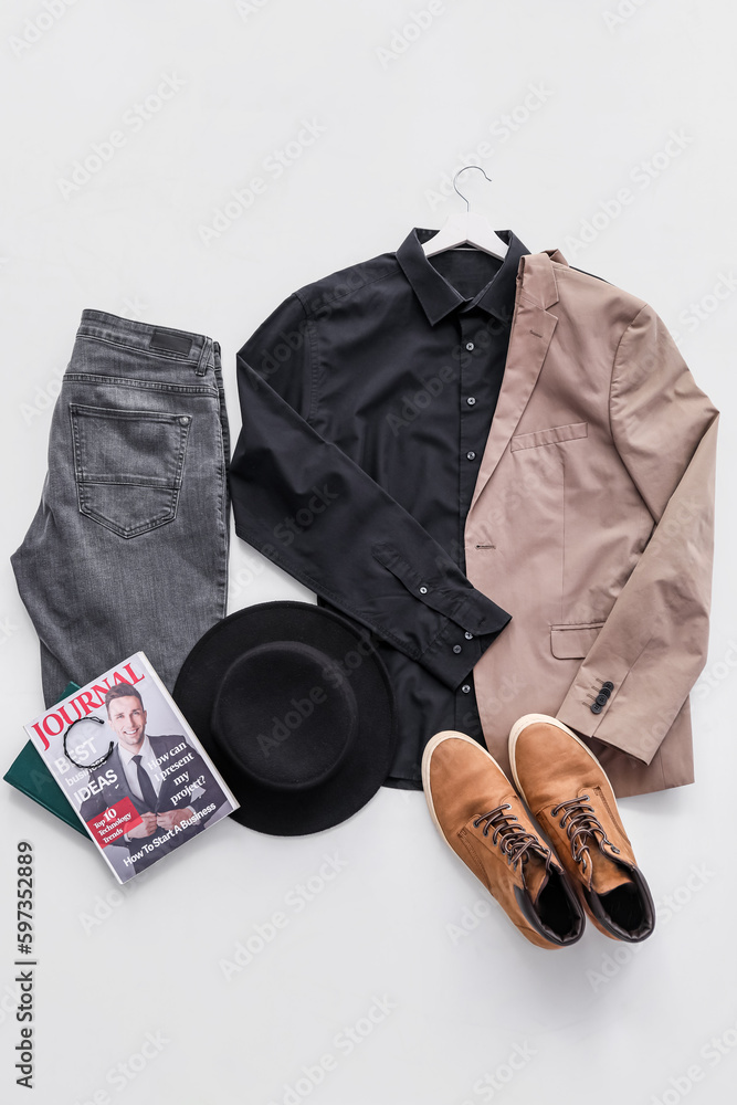 Stylish male clothes with hat, shoes and magazine on white background