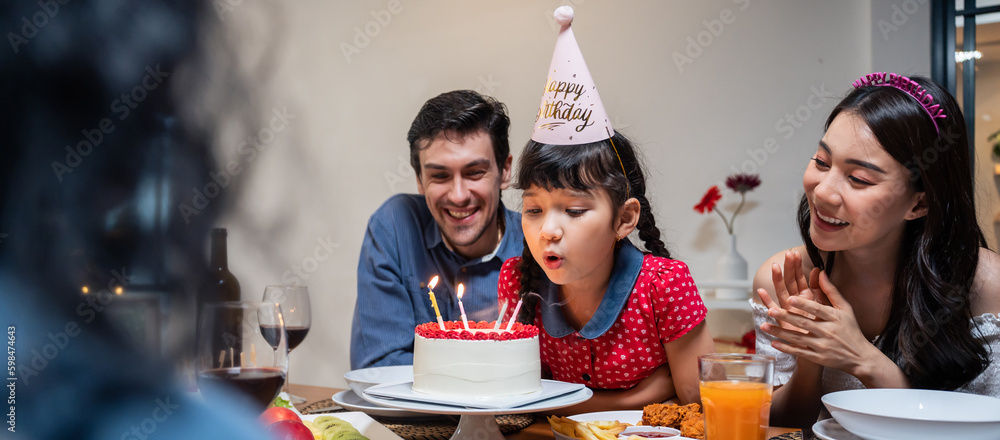 Multi-ethnic big family having a birthday party for young kid daughter.