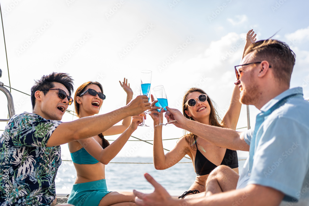 Group of diverse friends drink champagne while having a party in yacht. 