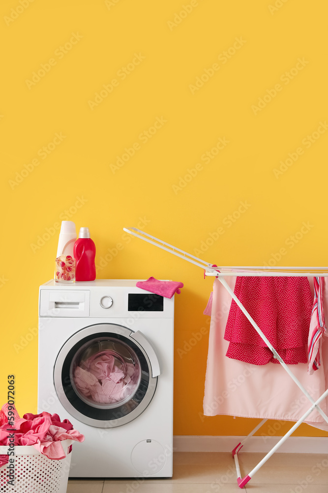 Basket with dirty clothes, washing machine and dryer in laundry room