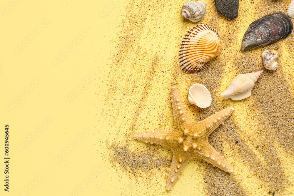 Sand with starfish and shells on light yellow background