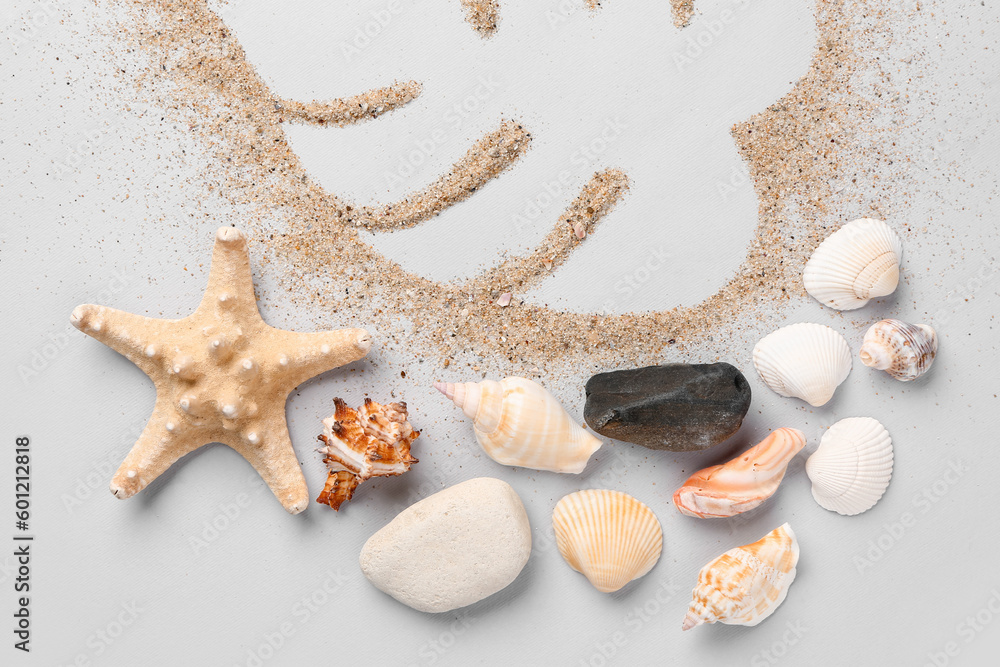 Palm leaf made of sand with starfishes and seashells on grey background