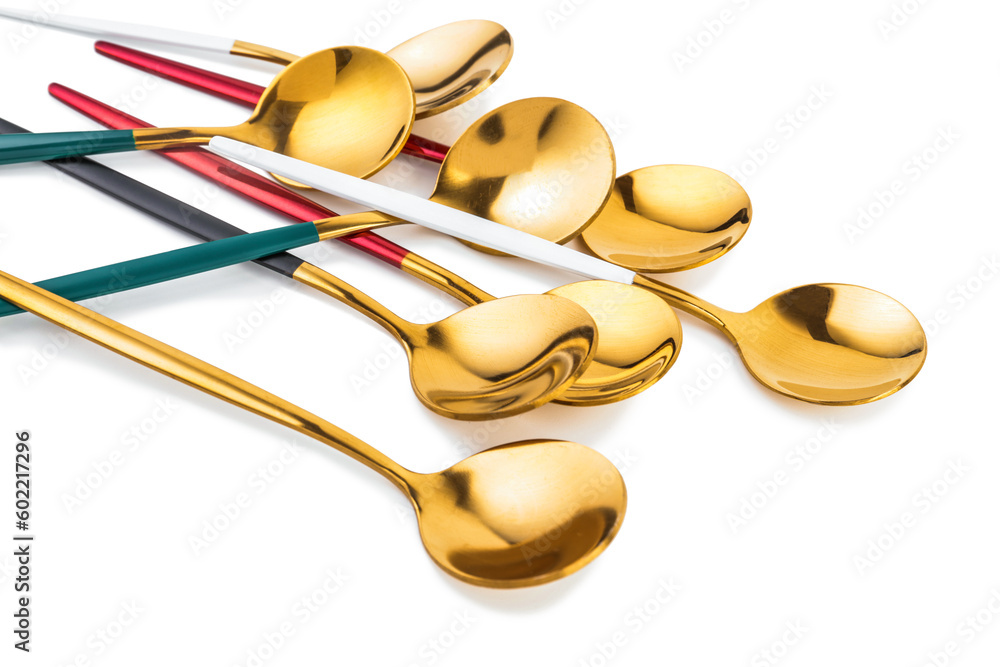 Golden spoons with colorful handles on white background