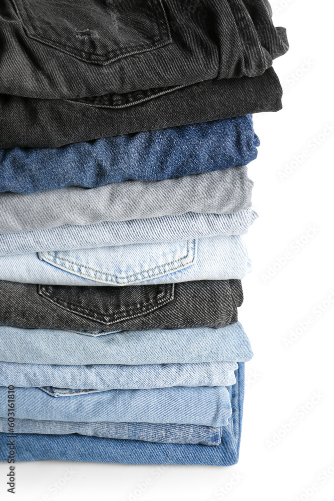 Different folded denim jeans on white background