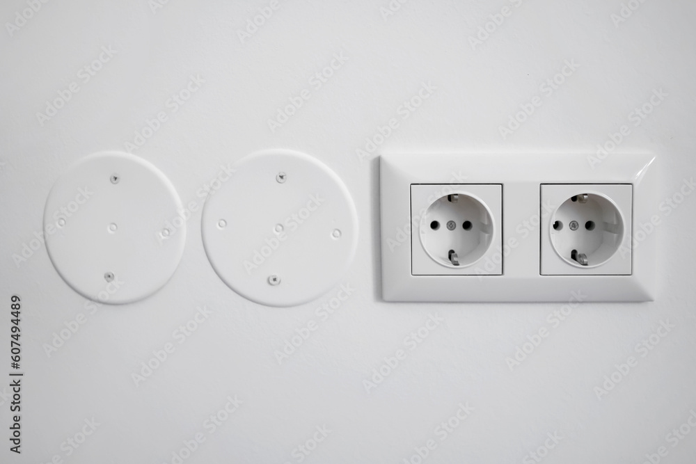 Electric sockets on white wall