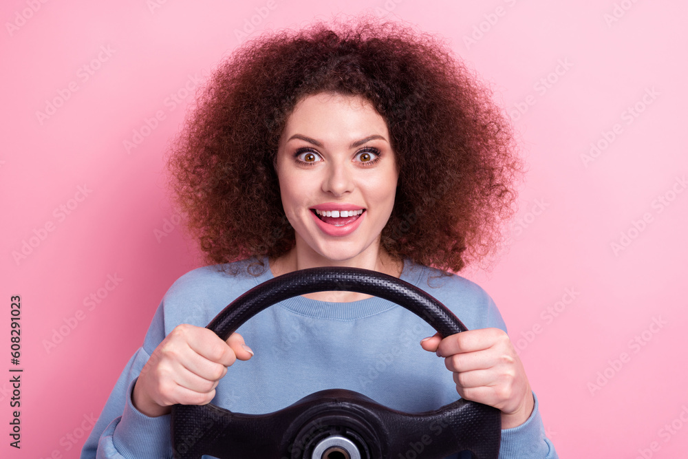 Photo of excited funky girl wear blue shirt smiling driving automobile isolated pink color backgroun