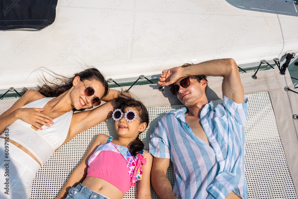 Caucasian attractive family lying down on deck of yacht while yachting. 