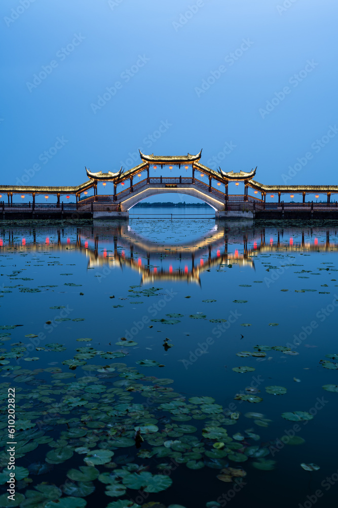 Chinese traditional style wooden bridge over the lake at night