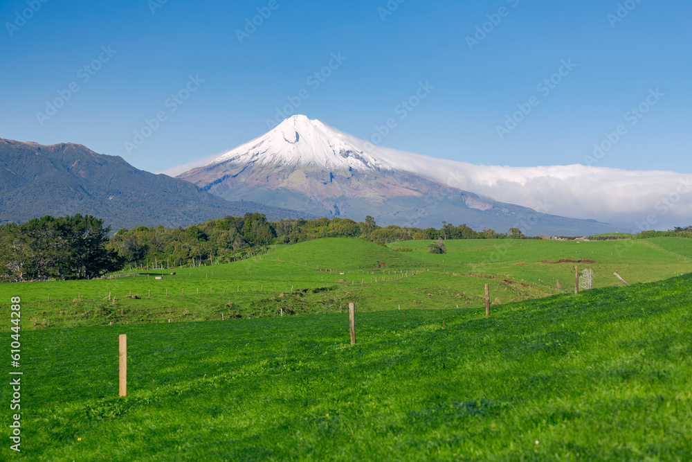 Grass farmland with mountain background, clear winter blue sky
