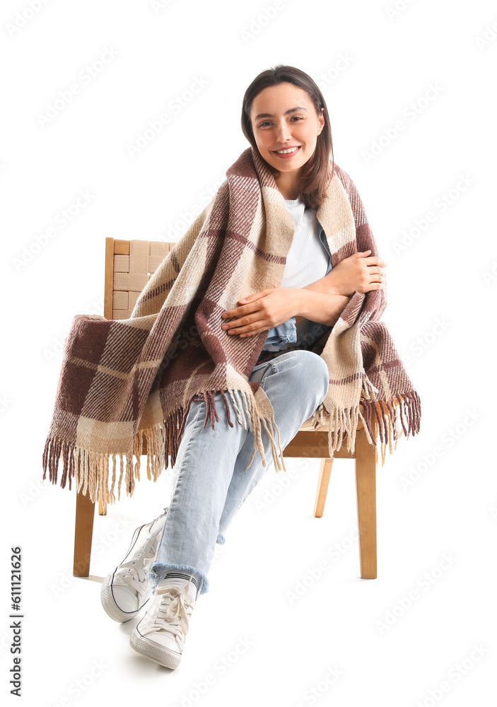 Young woman with plaid sitting in wooden armchair on white background