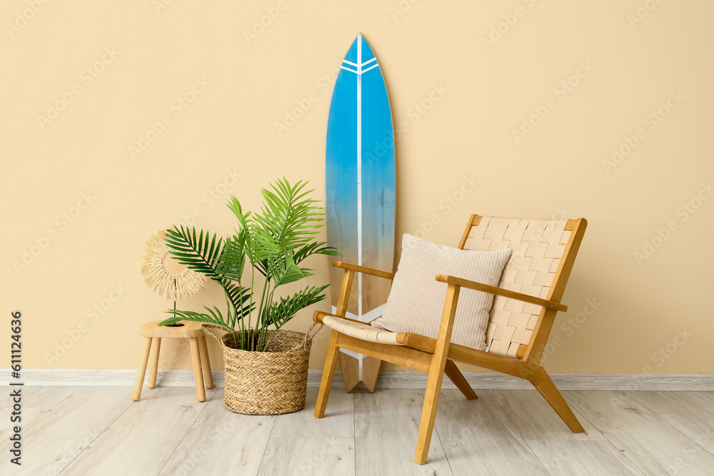 Interior of living room with surfboard, armchair and houseplant