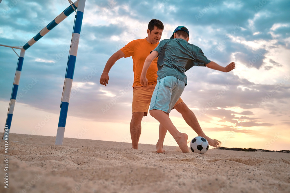 Father and Son playing football, family fun outdoors players in soccer in dynamic action have fun pl