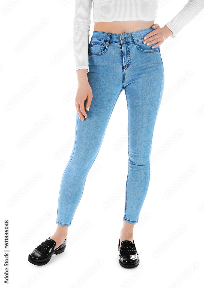 Young woman in skinny jeans on white background