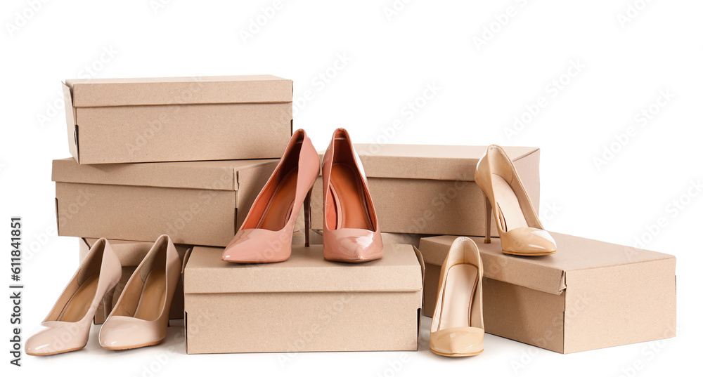 Cardboard boxes with beige high-heeled shoes on white background