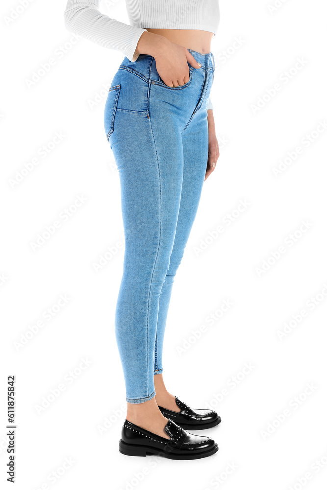 Young woman in skinny jeans on white background