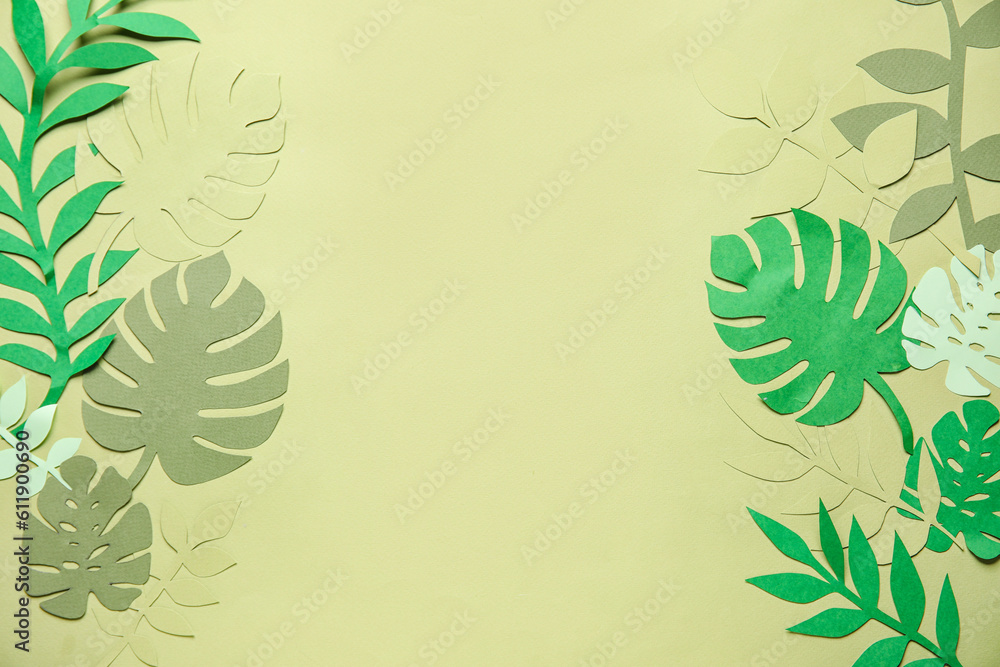 Frame made of different tropical leaves on pale green background