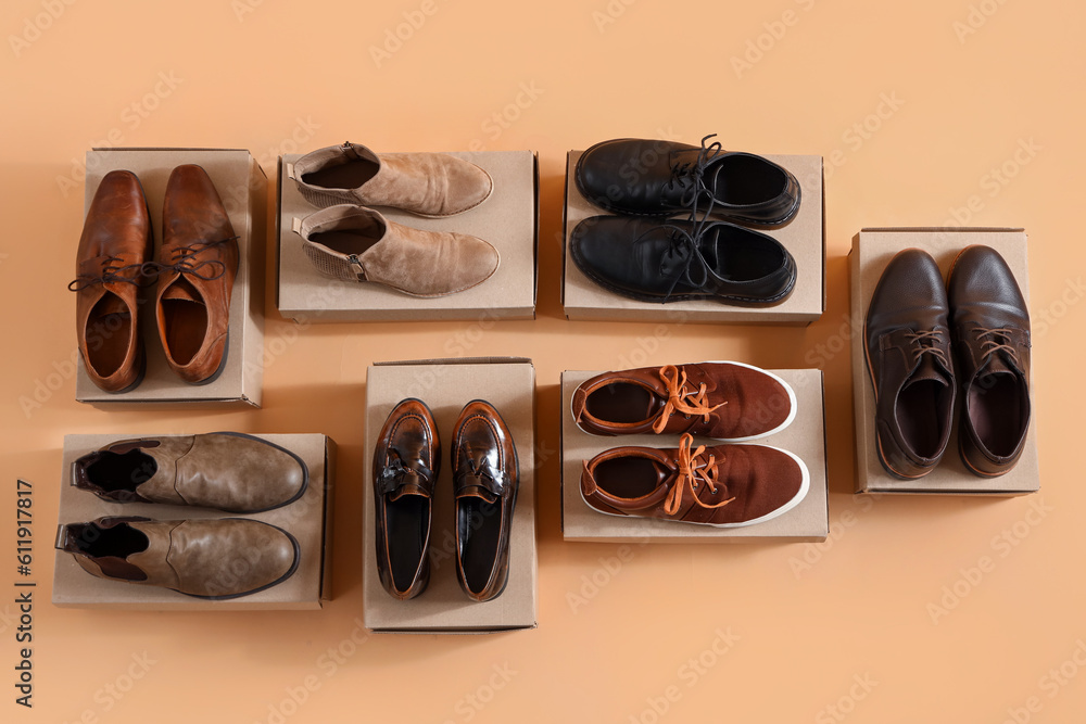 Cardboard boxes with different male shoes on beige background