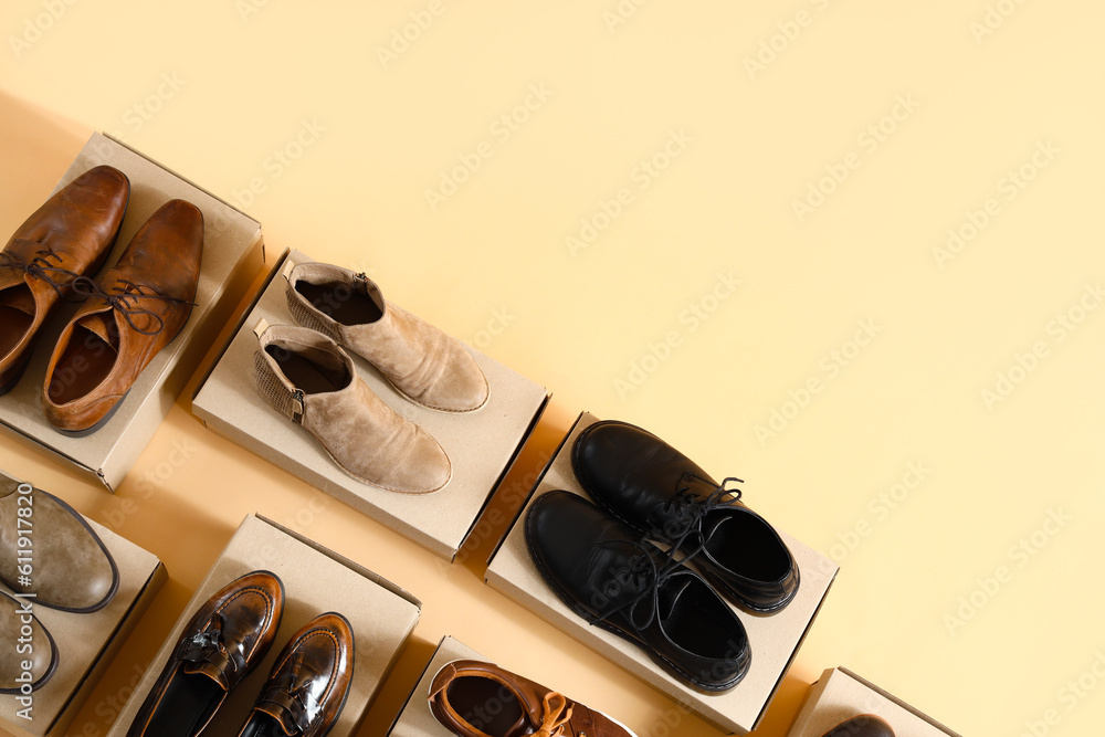 Cardboard boxes with different male shoes on beige background